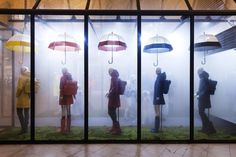 several people standing in front of glass with umbrellas