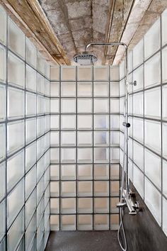 a bathroom with glass blocks on the walls and floor, as well as a shower head