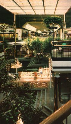 the inside of a building with lots of plants and benches on it's sides