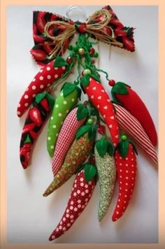 an assortment of decorative fruits and vegetables hanging from a string on a white wall with polka dots