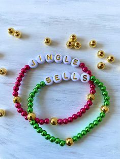 two beaded bracelets with the word jungle bells spelled out in gold and green beads