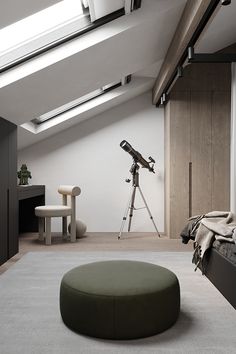 a bedroom with a large round ottoman in front of a window and a telescope on the wall