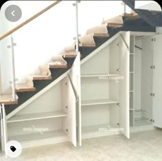 an empty room with some shelves and stairs in it's center, next to a closet