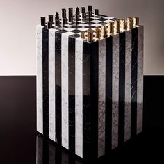 a black and white checkered marble block with gold trimmings sits on a table