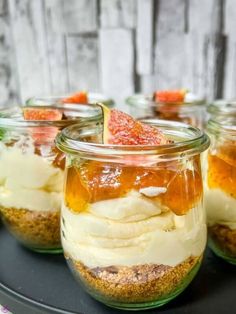 four jars filled with desserts sitting on top of a table next to each other