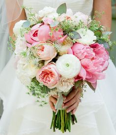 a bride holding a bouquet of pink and white flowers in her hands with the caption, there words or less describe this bouquet