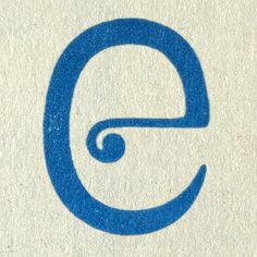 the letter e is written in blue on a white paper with a spiral design around it