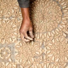 a person's hand on the floor with an intricate design