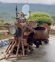 an old steam engine sitting on the side of a road