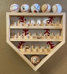 baseballs and other sports memorabilia are on display in a wooden wall - mounted shelf