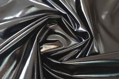 an image of shiny black material that looks like it has been coated with metallic foil