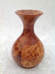 a wooden vase sitting on top of a white surface