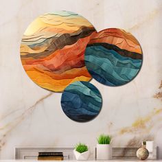 three circular artwork pieces hanging on the wall in a living room with marble walls and fireplace