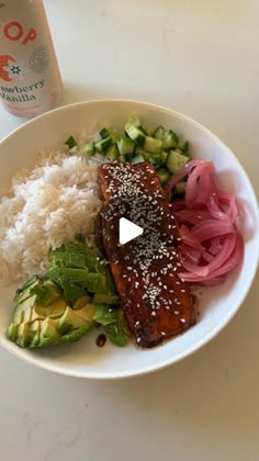 a white plate topped with meat and veggies next to a bottle of water