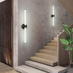 a staircase with two lights and a potted plant next to it