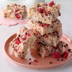 three pieces of rice krispy treats stacked on top of each other with raspberries and chocolate chips