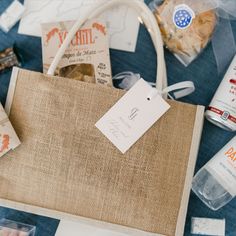 an assortment of personal care products are laid out on a blue table cloth with tags