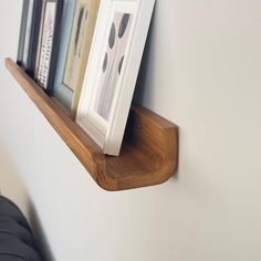 there is a wooden shelf with pictures on it