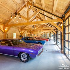 several classic muscle cars are lined up in a large room with wood paneling on the walls