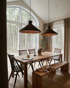 a dining room table with two hanging lights above it