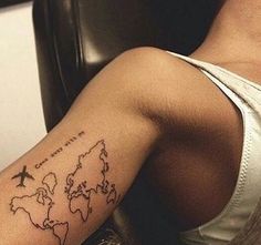 a person with a tattoo on their arm that has an airplane flying over the world