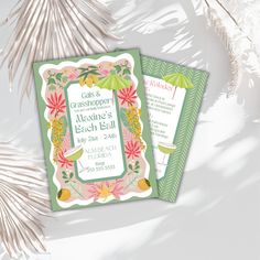 two green and pink wedding cards sitting on top of a palm tree