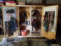 a wooden box filled with lots of different types of horse tacks and saddles