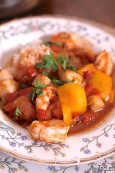 a white plate topped with shrimp and vegetables