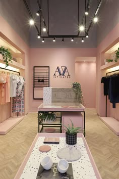 the interior of a clothing store with pink walls