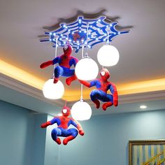 three spiderman lights hanging from the ceiling in a room with blue walls and stairs