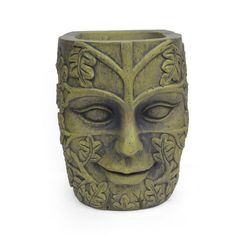 a green vase with a face on it