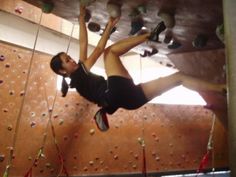 a woman climbing up the side of a rock wall