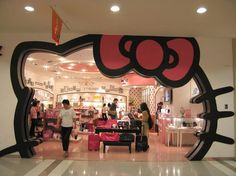 a hello kitty store with people standing in the doorway and looking at their products on display