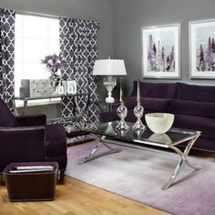 a living room filled with purple furniture and pictures hanging on the wall above the couches