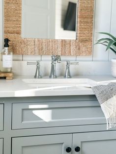 a bathroom sink sitting under a mirror next to a white counter top with a towel on it