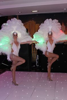 two women in white costumes dancing on a dance floor