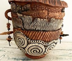 this is a ceramic cup that has been decorated with beads and other decorative things on it