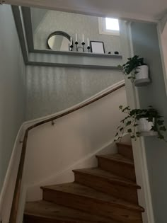 there is a mirror on the wall above some stairs