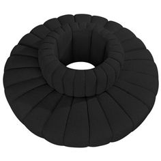 a black round cushion sitting on top of a white floor