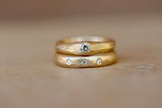 two gold wedding bands with diamonds on them