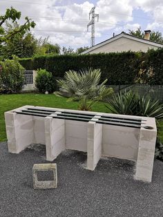 three cement benches sitting in the middle of a garden