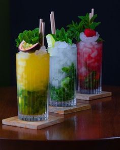 three different types of drinks sitting on top of a wooden table next to each other