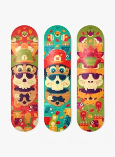 three skateboards with different designs on them, one has a skull and the other has a pirate hat