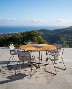 an outdoor table and chairs on a patio overlooking the ocean