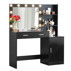 a black vanity with lights on it and a vase full of flowers in front of the mirror