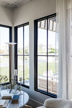 a living room filled with furniture and large windows