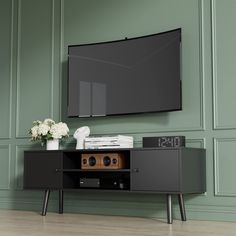 an entertainment center with a large flat screen tv mounted on the wall and two speakers