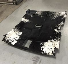 a black and white cowhide rug is laying on the floor in an industrial area