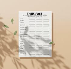 a sheet of paper with the words think fast on it next to a plant that is casting a shadow