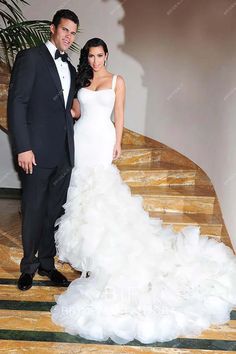 a man in a tuxedo and a woman in a wedding dress posing for the camera